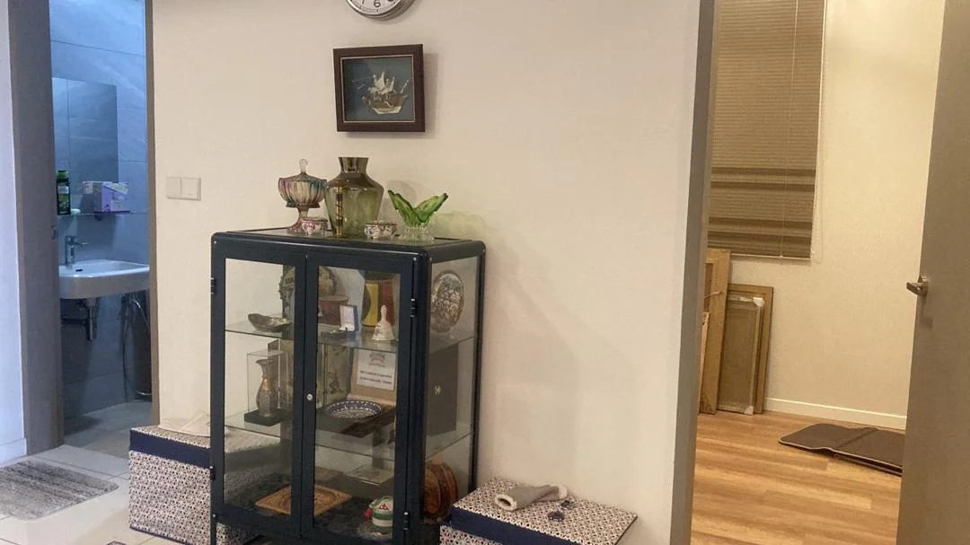 Room features: wooden flooring, white painted walls, wall clock, glass display cabinet, decorative items on cabinet, window with blinds, doorway leading to another room, framed artwork on wall; style: modern.